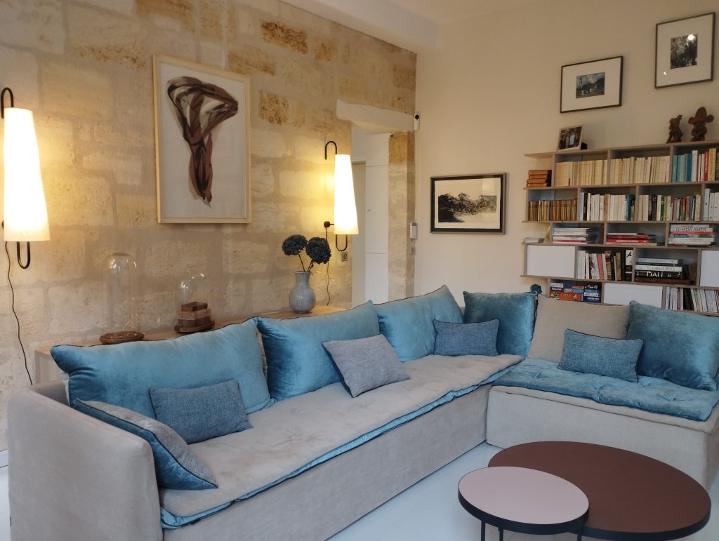 renovation et decoration appartement en pierre à bordeaux avec son salon tv bibliothèque et son canape d'angle