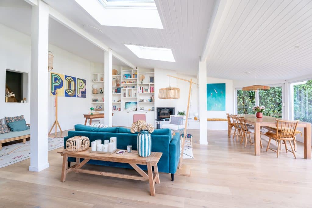 decoration interieure maison piece de vie salon avec canapé velours fauteuil rose tapis berbere table basse bois bureau bois salle à manger avec table et chaises bois et insert banquette sur mesure