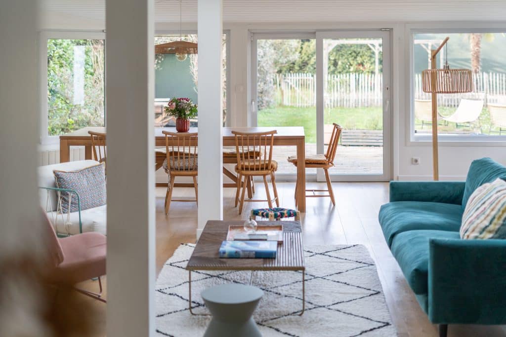 decoration interieure maison bordeaux salle à manger avec table et chaises en bois canapé velours et lampe sur pied bois tapis berbere