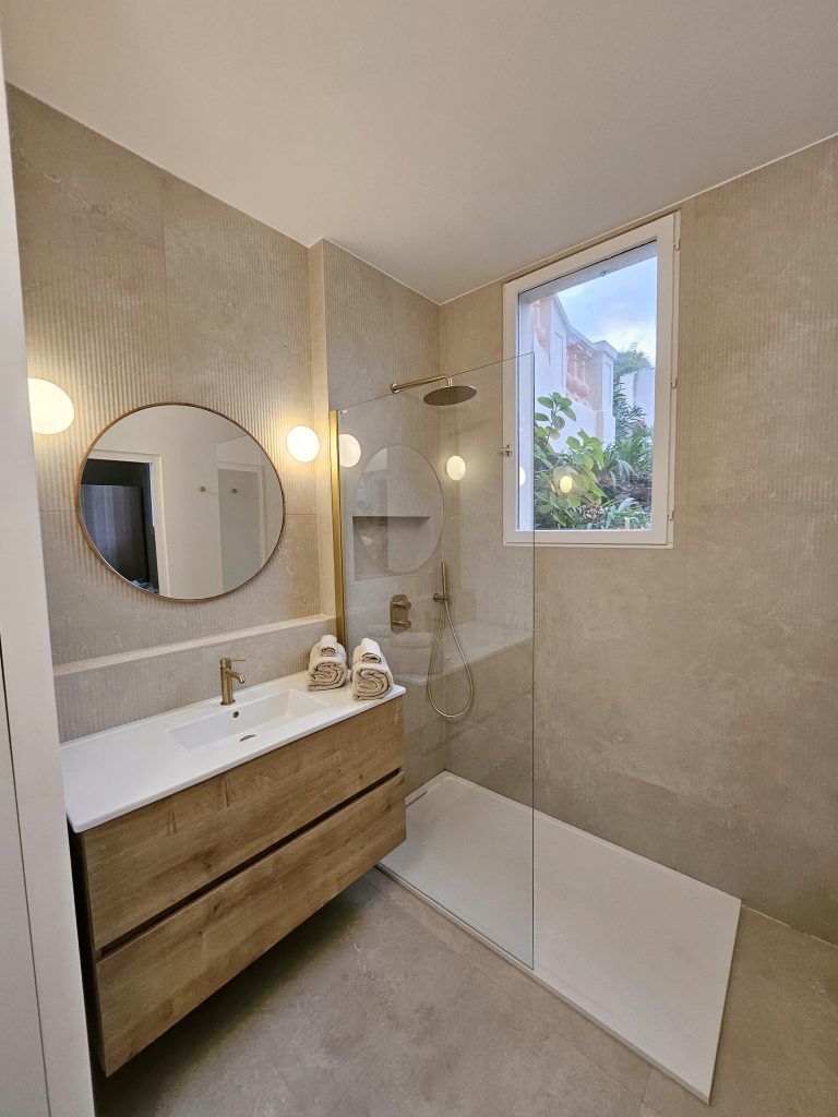 renovation salle de bain avec meuble vasque bois carrelage travertin et mitigeur laiton